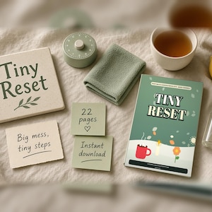 Könnte beinhalten: Ein Tiny Reset Druckset mit einem Heft mit roter Tasse, Kerze und Blumenmotiv, einem quadratischen Schild mit der Aufschrift Tiny Reset, zwei kleinen Textkarten, einem salbeigrünen Timer, einem gefalteten Tuch, einer Zitrone und einer Sprühflasche.