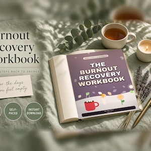 Könnte beinhalten: Ein Burnout Recovery Workbook mit violettem Einband, verziert mit einer roten Tasse, Blumen und dem Titeltext. Daneben liegen eine Karte mit der Aufschrift for the days you feel empty, ein Stift, eine Tasse Tee, eine Kerze und Lavendelzweige.