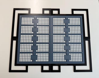 May include: A black rectangular frame with an intricate geometric border surrounds a gray grid insert. The gray insert features two vertical columns of five rectangular sections, each containing a small square grid pattern. The text XTOOL M2 FULL-RI FRAME is visible.