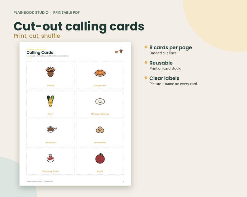 May include: A printable PDF sheet titled Cut-out calling cards by Plainbook Studio. The page features eight rectangular cards with dashed cut lines, each displaying a small colorful illustration and text label for items like turkey, pumpkin pie, corn, mashed potatoes, gravy boat, dinner rolls, cranberry sauce, and apple.