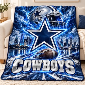 May include: A plush throw blanket featuring a Dallas Cowboys football helmet, a large blue star logo, a football, and a city skyline background with lightning effects. The word COWBOYS is printed in large, metallic-style block lettering.