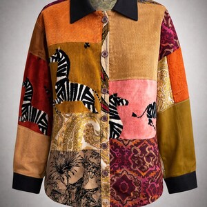 May include: A patchwork button-down shirt with a black collar and cuffs. The shirt features various fabrics in shades of orange, brown, pink, and burgundy, with zebra and paisley patterns. The shirt has long sleeves and a button-up front.