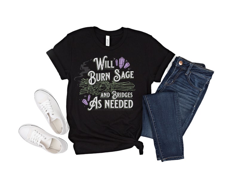 May include: Black t-shirt with a white graphic that says "Will Burn Sage and Bridges As Needed". The graphic also includes a purple crystal and a bundle of sage.