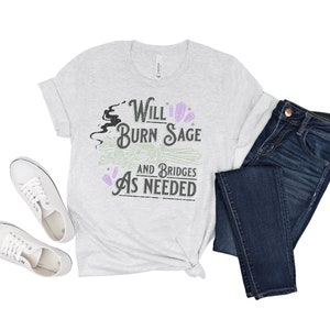 May include: A heather grey t-shirt with a black and green graphic that says "Will Burn Sage and Bridges As Needed".
