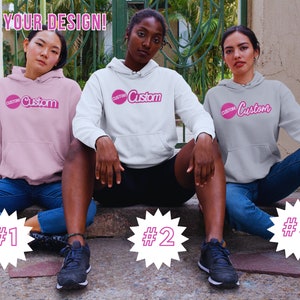 May include: Three people wearing hoodies with the word "Custom" in pink lettering on the front. The hoodies are pink, white, and gray. The people are sitting on a set of stairs with numbers 1, 2, and 3 behind them.