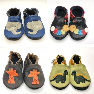 Peut inclure: Quatre paires de chaussons pour bébé avec différents motifs d'animaux. La première paire est bleue avec un motif d'éléphant blanc. La deuxième paire est noire avec un motif de perles colorées. La troisième paire est noire avec un motif de girafe. La quatrième paire est verte avec un motif de dinosaure.