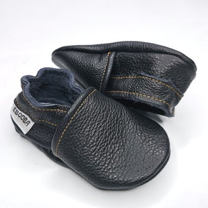May include: Black leather baby shoes with a yellow stitch detail and the word "Ebooba" on the side.