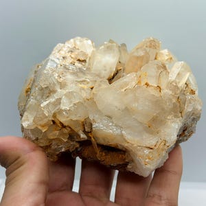 Grupo de cuarzo miel champán natural, cristales grandes translúcidos, manchas de óxido de hierro, muestra de mineral en bruto.