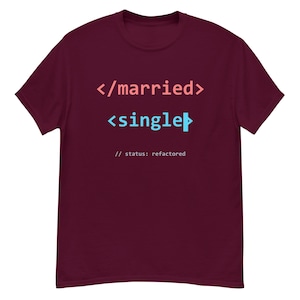 Puede incluir: Una camiseta de manga corta color granate con texto en blanco y azul claro. El gráfico muestra el fragmento de código </married> seguido de <single> con una barra de cursor vertical y el texto // status: refactored en una fuente blanca más pequeña.