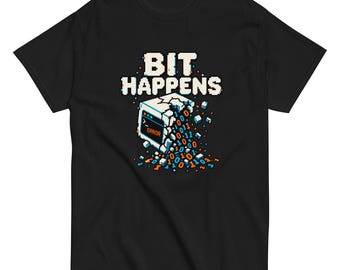 May include: A black short-sleeve t-shirt featuring a pixel art graphic of a crumbling computer monitor displaying the text ERROR. Above the monitor, the text BIT HAPPENS is printed in white pixelated letters, with blue and orange binary digits.