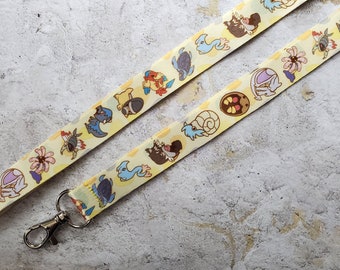 May include: A yellow lanyard with a repeating pattern of cartoon characters. The lanyard has a silver clip on one end.