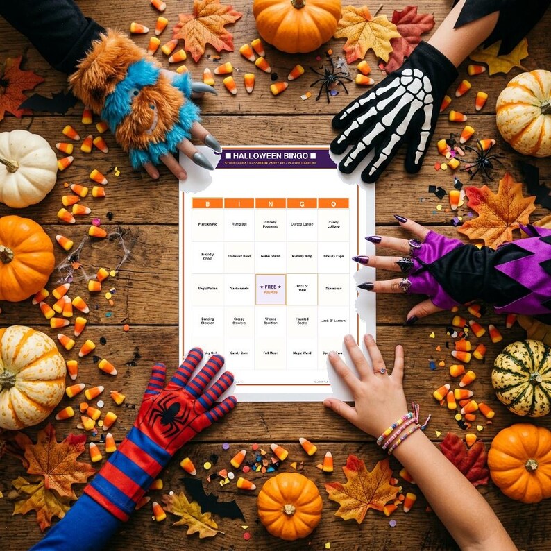 May include: A Halloween Bingo game card featuring a grid with text, surrounded by orange pumpkins, autumn leaves, and candy corn. The card has a purple header with the text Halloween Bingo and a central free space, displayed on a wooden surface.