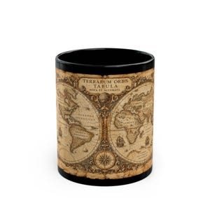 May include: A black ceramic mug featuring a vintage-style world map print in sepia tones. The design displays continents and oceans with the Latin text Terrarum Orbis Tabula Nova Et Accurata at the top, along with decorative compass and ship illustrations.