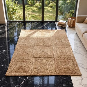 May include: A rectangular area rug crafted from natural tan jute fibers, featuring a grid pattern of nine square sections. Each square is composed of concentric braided jute rows that spiral inward toward a central point, creating a textured surface.
