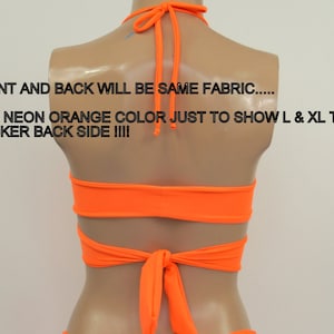 May include: Back view of a neon orange halter top with a criss-cross design and a tie at the back. "FRONT AND BACK WILL BE SAME FABRIC..... THIS NEON ORANGE COLOR JUST TO SHOW L & XL TOPS THICKER BACK SIDE !!!!" is written on the image.