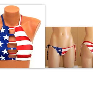 May include: A two-piece bikini set featuring a halter top and string bikini bottoms. The top is blue with white stars and red and white stripes. The bottoms have a matching design. The swimwear is displayed on mannequins.