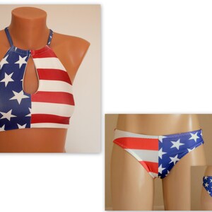 May include: A two-piece swimsuit featuring the American flag design. The halter-style top has a keyhole detail, and the bottoms are a classic bikini cut. The patriotic swimwear is displayed on mannequins.