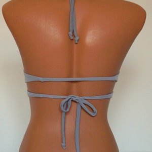 May include: A light gray halter bikini top with adjustable straps and a tie back.