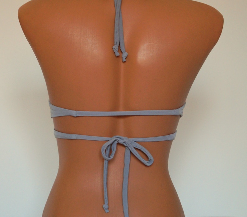 May include: A light gray halter bikini top with adjustable straps and a tie back.