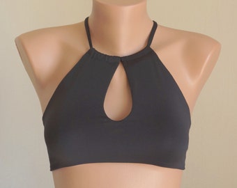 May include: A black halter top with a keyhole cutout in the front. The top is made of a soft, stretchy fabric.