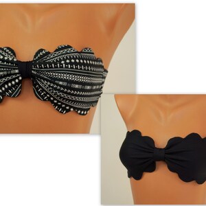 May include: A black and white patterned bandeau bikini top with a bow in the centre. The top has a scalloped edge. A second image shows a solid black bandeau bikini top with a bow and scalloped edge.