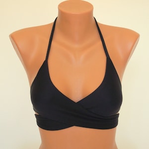 May include: Black halter-style bikini top with a criss-cross design in the front.