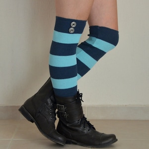 May include: A pair of blue and white striped knee-high socks with a button detail on one sock. The socks are worn with black combat boots.