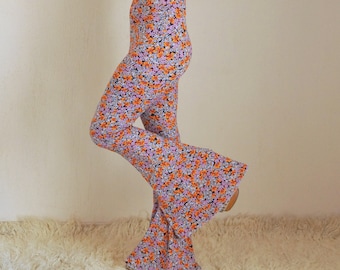 May include: A pair of wide-leg pants with a floral print in shades of orange, pink, and white. The pants have a high waist and a flared leg.