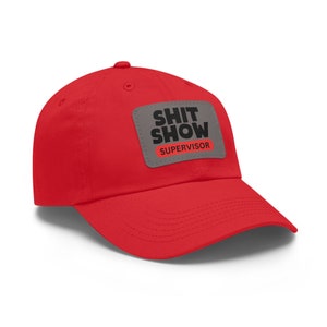 May include: Red baseball cap with a grey patch that says "SHIT SHOW SUPERVISOR" in black and red lettering.