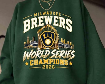 May include: A dark green crewneck sweatshirt featuring a graphic print that reads Milwaukee Brewers World Series Champions 2026. The design includes a gold baseball glove logo, a stadium silhouette, and two gold stars on the front.