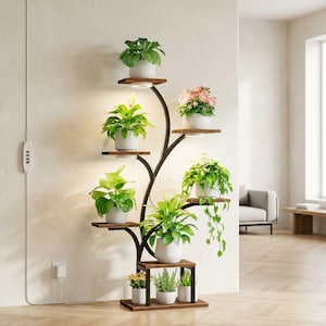 May include: A tall, branching metal plant stand with a black finish, featuring multiple wooden shelves at varying heights. The stand holds several potted plants, including green foliage and pink flowers, with integrated circular LED lights.