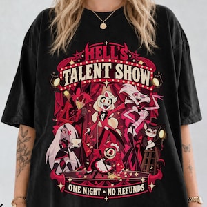 May include: A black t-shirt featuring a graphic print titled HELL'S TALENT SHOW with the text ONE NIGHT NO REFUNDS. The design displays a group of animated characters in red and white tones, set against a theatrical stage backdrop with spotlights.