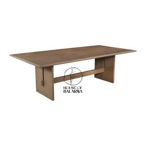 Pode incluir: Uma mesa de jantar retangular de madeira castanha com superfície lisa e bordas chanfradas. A mesa possui duas pernas verticais de placa sólida conectadas por uma viga de suporte horizontal. O logotipo House of Balarwa está impresso em preto.