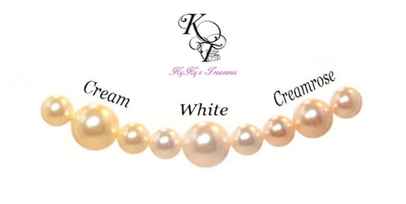 May include: A row of pearls in different shades of white, cream, and creamrose. The pearls are arranged from left to right in order of color, with the darkest shade on the left and the lightest shade on the right. The pearls are labeled with their respective colors.