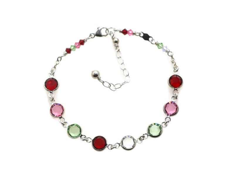 Sterling Silver birthstone bracelet with 8 rhodium plated round birthstone links on diamond cut cable chain. Closes with a sterling silver lobster claw clasp with extender chain to make it adjustable.