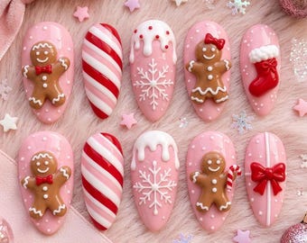 May include: A set of ten almond-shaped press-on nails featuring pink bases with white polka dots, decorated with 3D gingerbread figures, red and white candy cane stripes, white snowflakes, a red stocking, and a red gift bow.