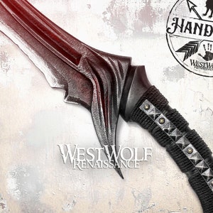 May include: A black and silver fantasy-style sword with a textured blade and a black leather-wrapped handle with metal studs. The sword is on a white and red textured background with a black and white logo that says "Handmade Westwolf".