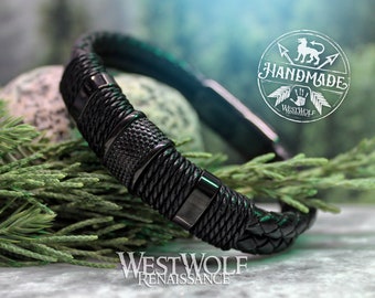 May include: Black leather bracelet with woven and textured details. The bracelet features a magnetic clasp and is accented with metal hardware. The image includes the text "HANDMADE" and "WESTWOLF RENAISSANCE".