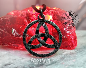 May include: A green metal Celtic knot pendant necklace with a circular design. The necklace is on a red rock and a white surface. The text "Handmade" is visible in the image.