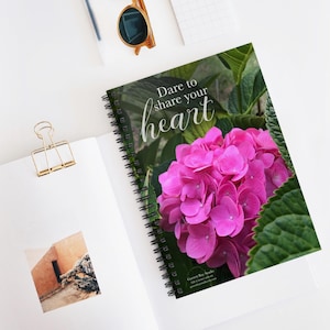 May include: A spiral bound notebook with a pink hydrangea flower on the cover. The text "Dare to share your heart" is printed on the cover.