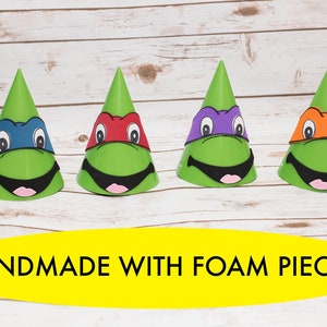 May include: Four green party hats with different colored masks. The masks are red, purple, blue, and orange. The hats are handmade with foam pieces. The text "HANDMADE WITH FOAM PIECES" is on a yellow banner below the hats.