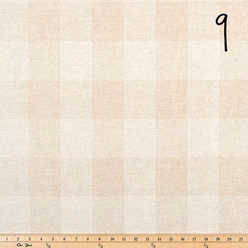 Puede incluir: Primer plano de una tela de vichy beige y blanca con una regla que mide 53,3 cm.