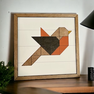 May include: Geometric wooden wall art featuring a stylized bird in shades of brown, orange, and black. The bird is framed in a natural wood frame.