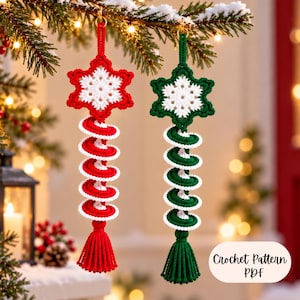 May include: Two hanging crochet ornaments featuring a white snowflake center attached to a spiral tail and a tassel. One ornament is red and white, and the other is green and white. The text "Crochet Pattern PDF" is visible in the bottom right corner.