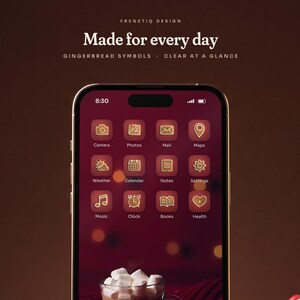 Close view of the Gingerbread Classic home screen on a phone: white-iced gingerbread symbols on cranberry red tiles with clear labels over the hot cocoa and gingerbread man wallpaper.