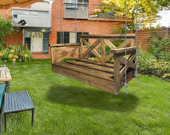 May include: A wooden swing bench with a criss-cross design on the back and sides. The swing is hanging from a tree branch in a backyard setting.