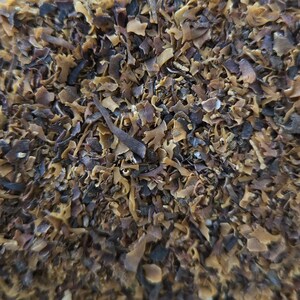 Peut inclure: Gros plan sur un tas d'algues séchées, avec un mélange de morceaux bruns et violet foncé.