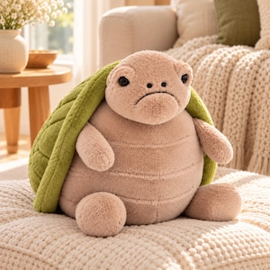 May include: A plush turtle toy with a soft, light beige body and a textured, olive green shell. The stuffed animal features a rounded, plump shape, small limbs, and a simple face with dark, round eyes and a stitched mouth line.