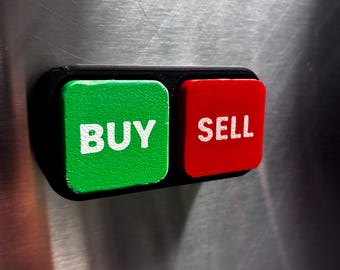 May include: A rectangular black plastic base holds two square buttons. The left button is green with the white text BUY, and the right button is red with the white text SELL. The object is mounted on a metallic surface.