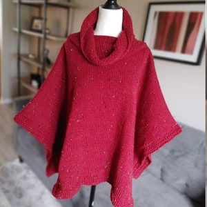 以下が含まれることがあります： 斑点模様の赤いニットのタートルネックポンチョ